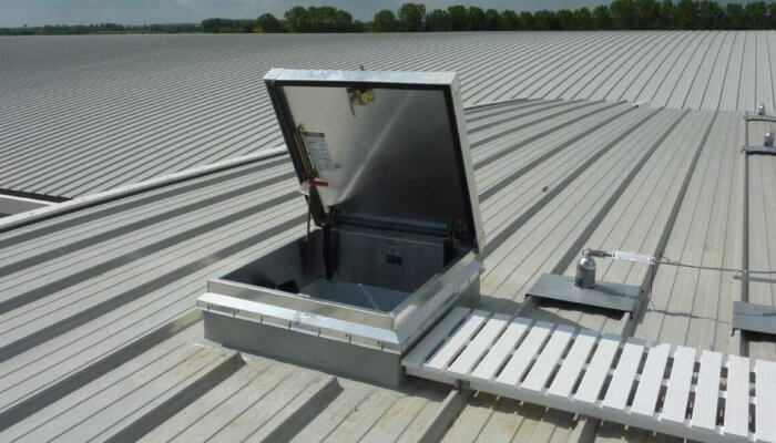 Bilco access hatch with a white walkway on a weatherproofed roof